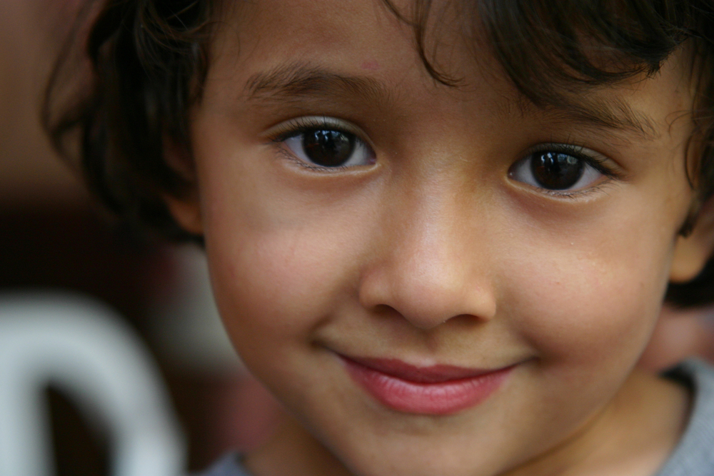A young orphan girl smiles into the camera